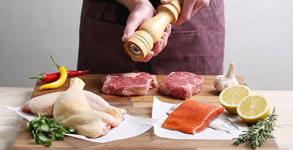 A photograph of a selection of meat and fish being prepared