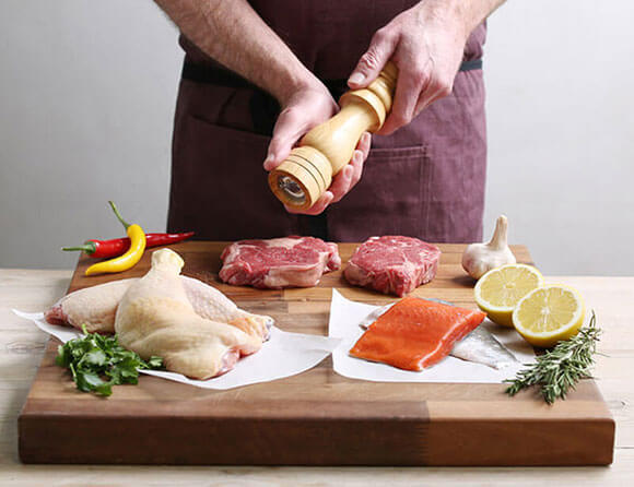 A photograph of a selection of meat and fish being prepared