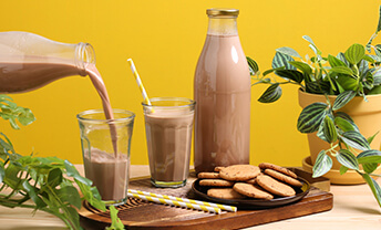 Pour a glass of Rerooteds organic oat chocolate milk
